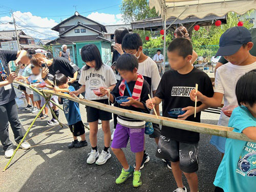 陽だまり　安　活動のようす画像　素麺流しを楽しむ大勢の子どもたち